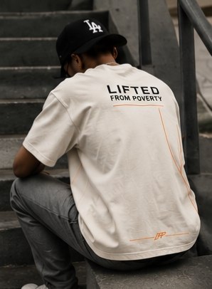 Wearing the tee, seated on city stairs